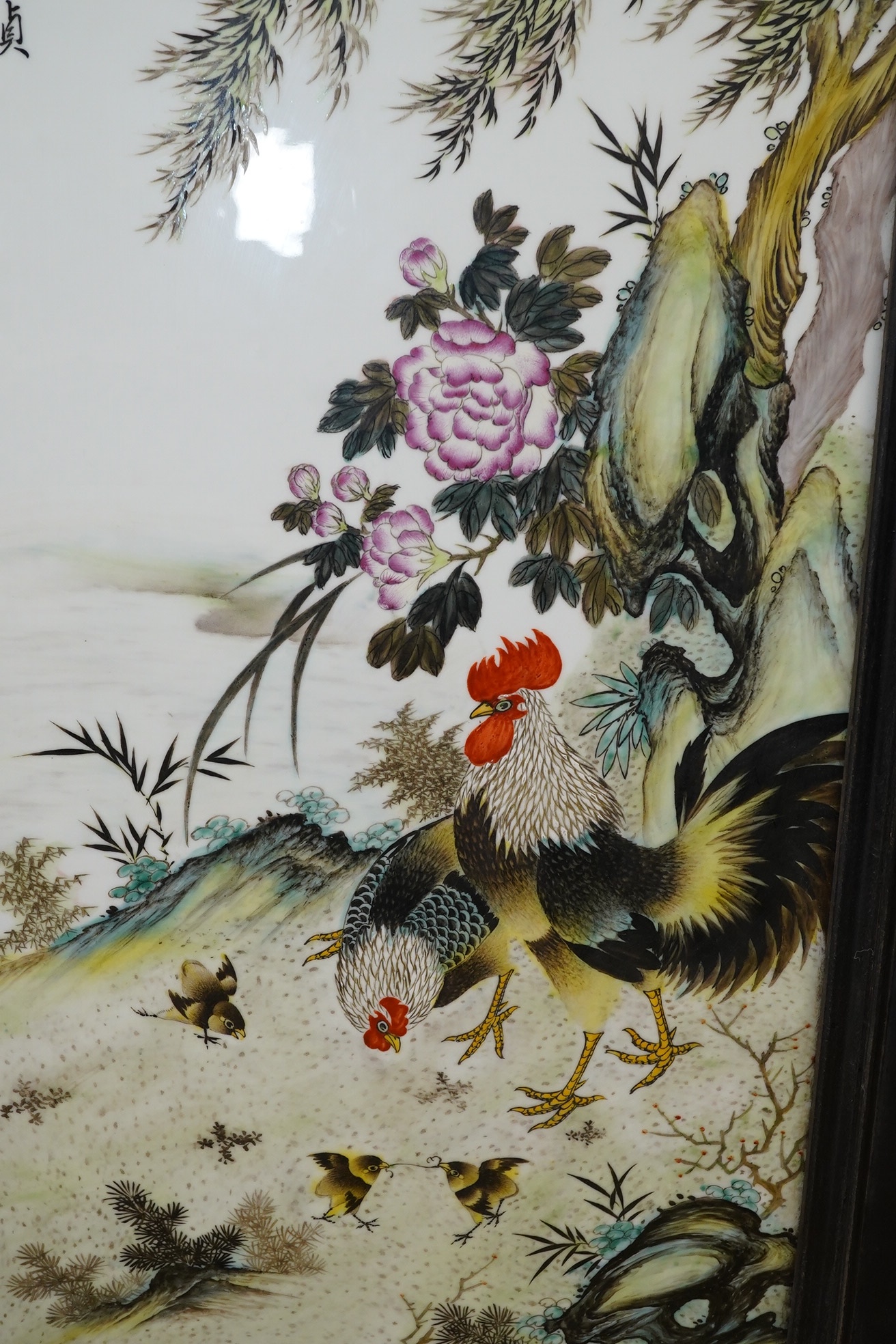 A Chinese famille rose porcelain plaque depicting cockerels and chicks before a landscape, signed with character marks and red seal mark, framed, 95cm high. Condition - good